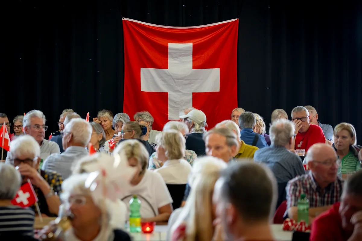 Wegen der schlechten Witterung fand die Feier im Chesselhuus statt. Eine sitzende Menschenmenge.